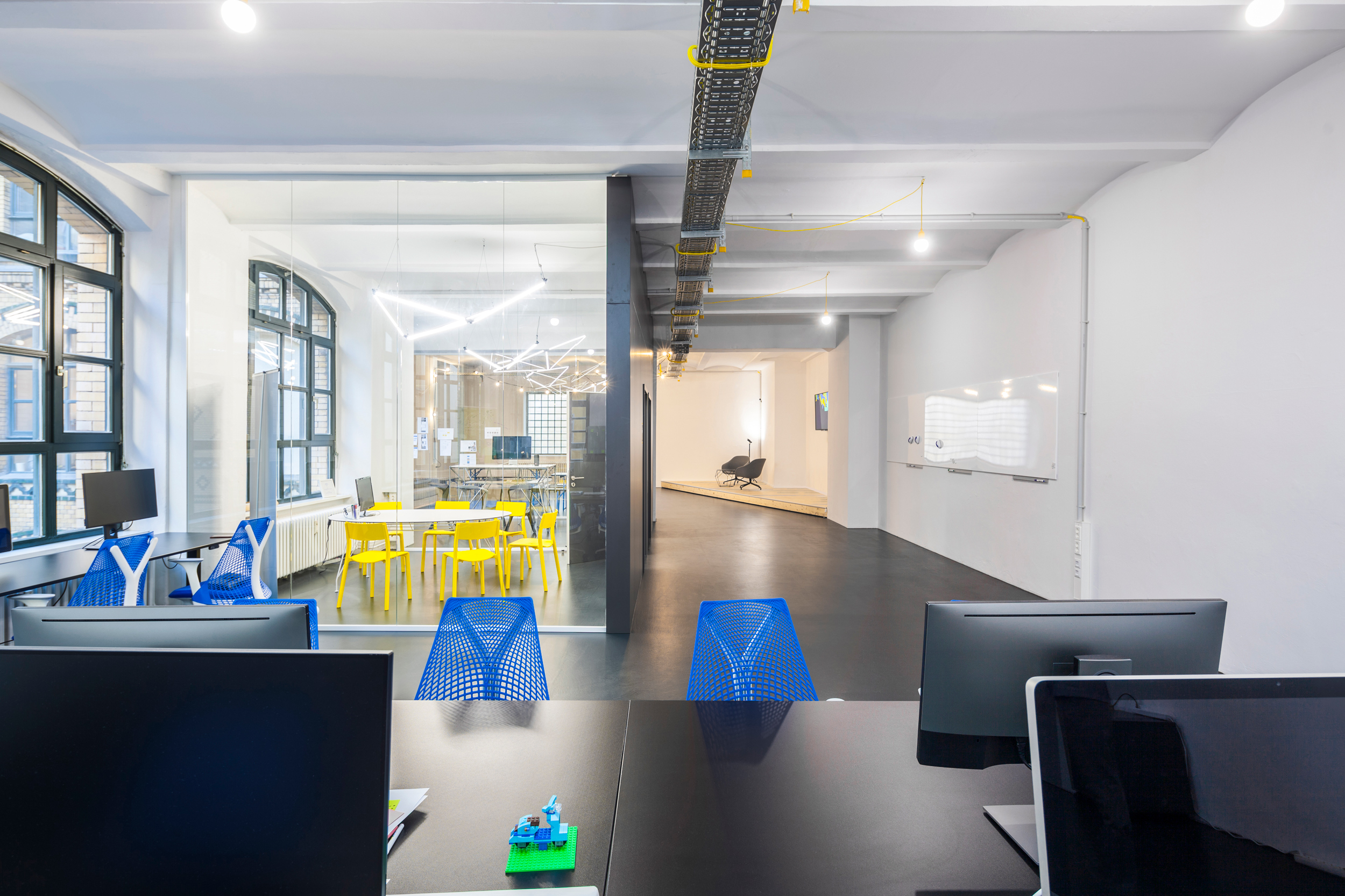 Büroloft mit Schreibtischstühlen und Meetingraum.